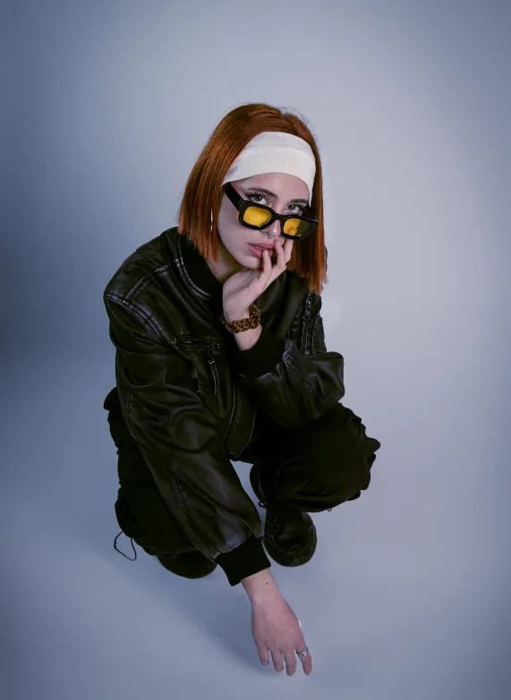 Artista pelirroja con anteojos amarillos y campera de cuero